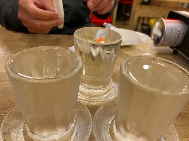 日本酒グラス三杯が並ぶテーブル風景