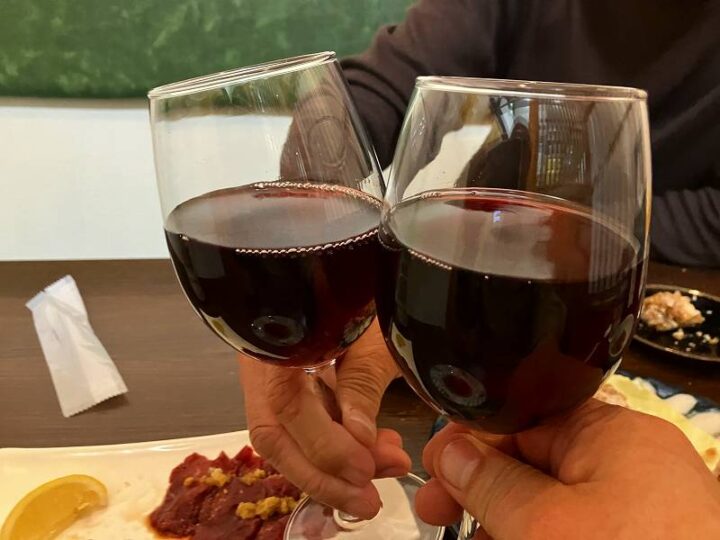 赤ワインのグラスで乾杯する様子