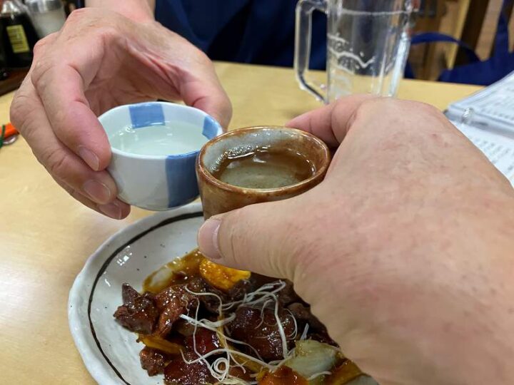 信州健康ランド大広間で日本酒の盃を合わせる
