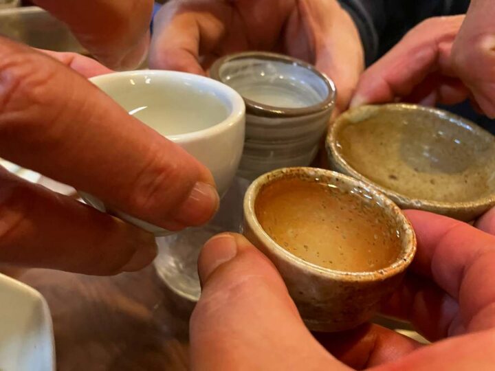 ぐい呑みを囲んで日本酒を飲み比べる様子