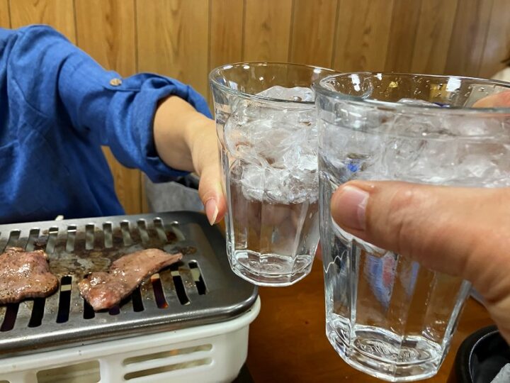 焼肉を前に焼酎で乾杯する様子
