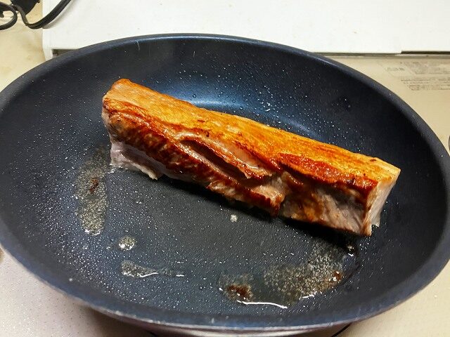 フライパンで表面を焼いている豚バラ肉