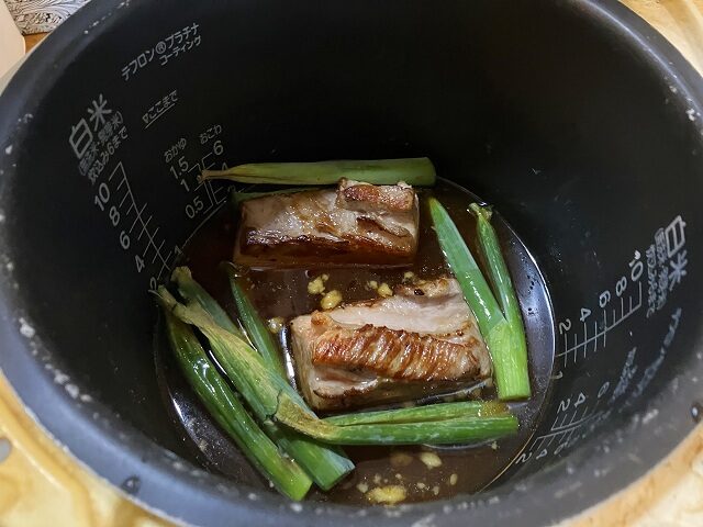 焼き上げた豚バラチャーシューをタレに浸した