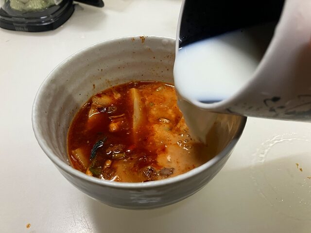 辛ラーメンのスープに牛乳を加えている様子