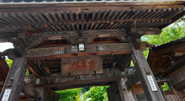 たくさんの千社札が貼られた修禅寺の歴史ある山門の木製天井