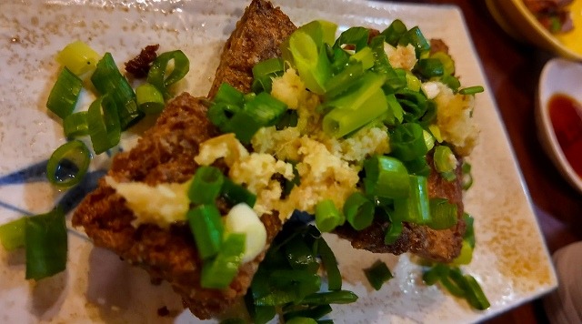 香ばしく焼いた厚揚げにねぎと生姜を添えた一皿