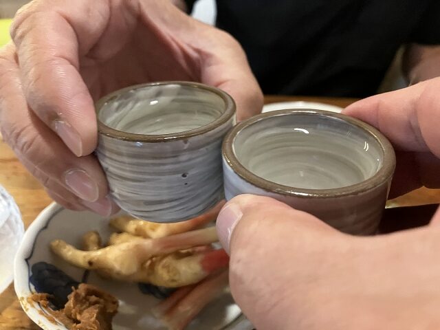 住よしでインディゴ94の純米吟醸をおちょこで乾杯する様子