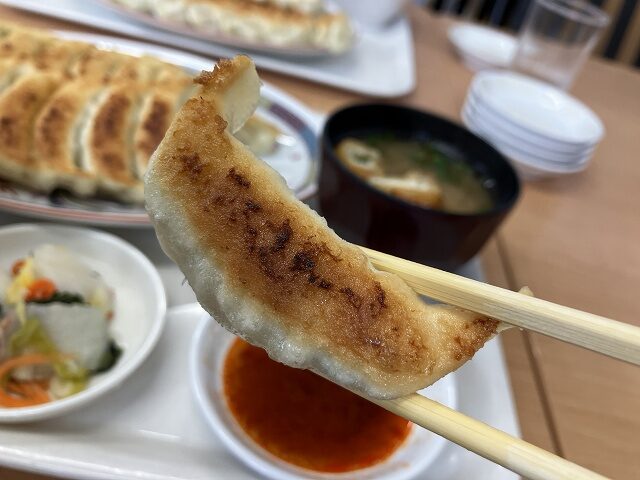 焼きたての福みつ餃子を箸で持ち上げた様子
