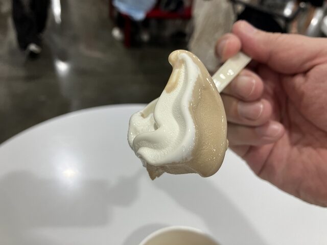 北海道ソフトクリームとほうじ茶ソフトクリームのミックスをスプーンですくった様子