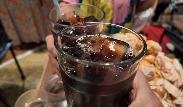 大きなグラスのアイスコーヒーで乾杯