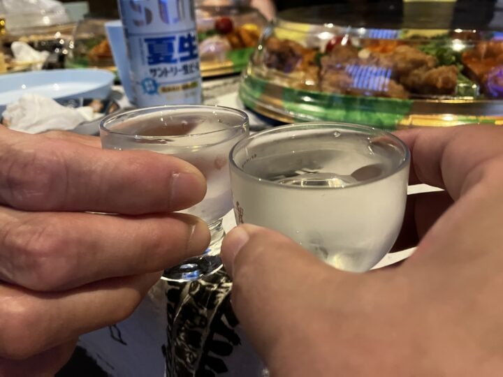 澄んだ日本酒が入ったグラスを合わせて乾杯