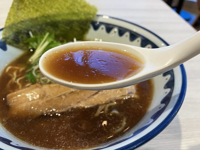 レンゲですくった麺屋道神の醤油ラーメンのスープ
