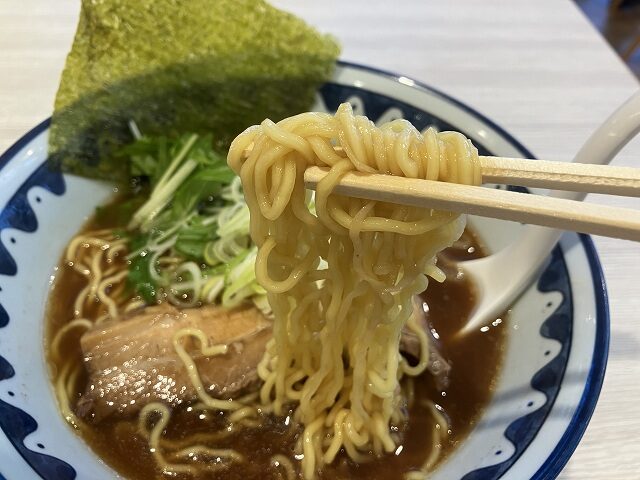 箸で持ち上げた麺屋道神の道神醤油ラーメンの麺