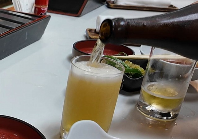 天錦のカウンターでグラスへ注がれる瓶ビール