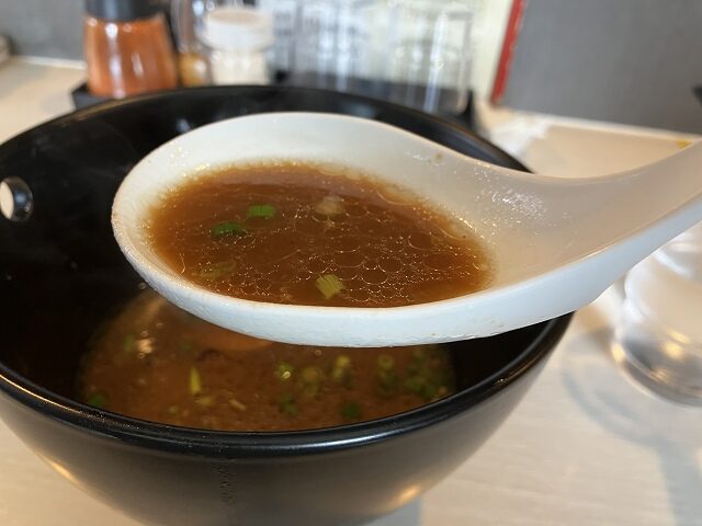 白いレンゲですくった青空きっど零壱の中華そばのスープ