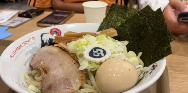 チャーシューや味玉に55ナルトがトッピングされたつけ麺の盛り付け