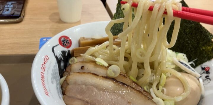 お箸で高くリフトアップしたフジヤマ55の自家製極太麺と分厚いチャーシュー