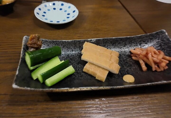 もろきゅうや油揚げの煮物などが盛り合わされた酒の肴プレート