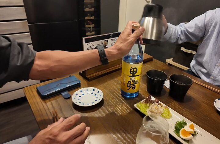 奄美黒糖焼酎「里の曙」のボトルとお湯割りポットが置かれたテーブル