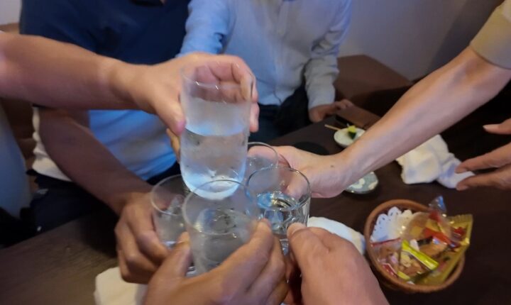大先輩も一緒に全員でグラスを突き合わせて盛り上がる乾杯の様子