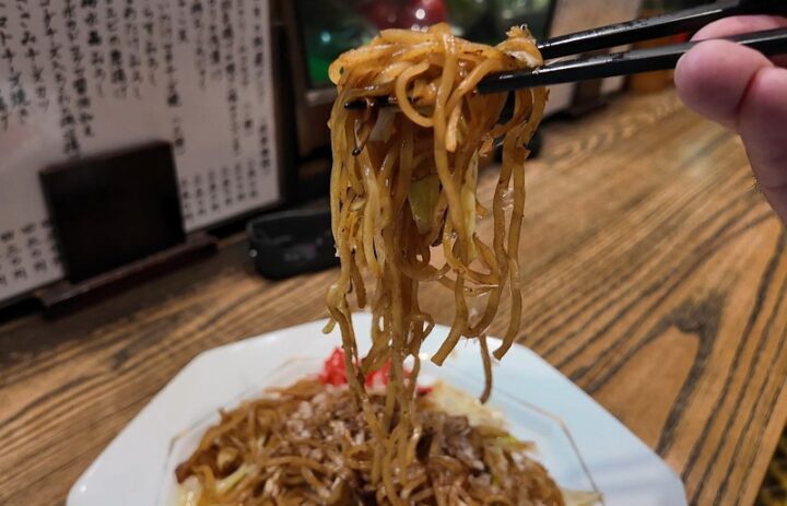 箸で高く持ち上げられたツヤツヤでコシの強い富士宮やきそば