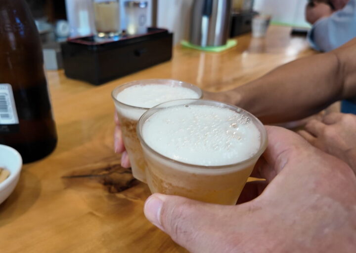 カウンターで冷たいビールグラスを合わせて乾杯