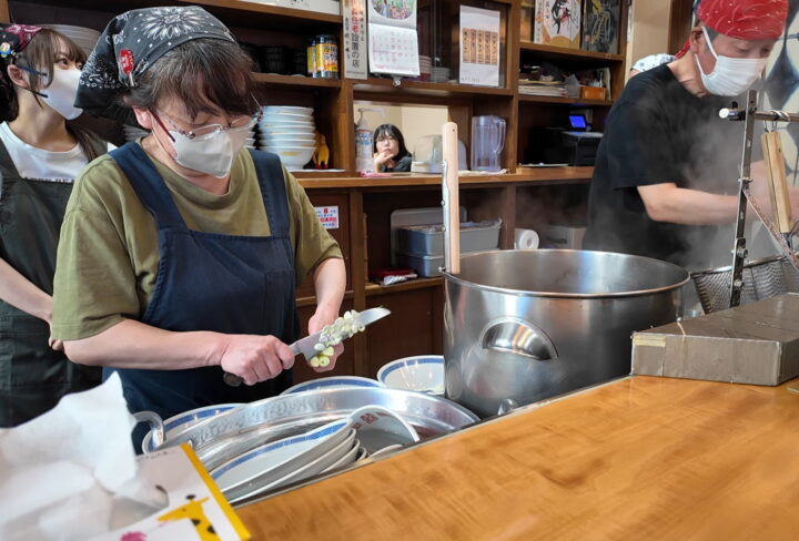 丼の上で手際よく包丁を使ってネギを刻み落とすおかあさんの空中ネギ切り