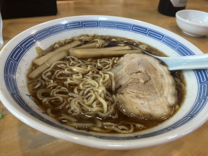 濃い醤油色のスープにチャーシューとメンマ、ネギが美しく盛られた中華そば