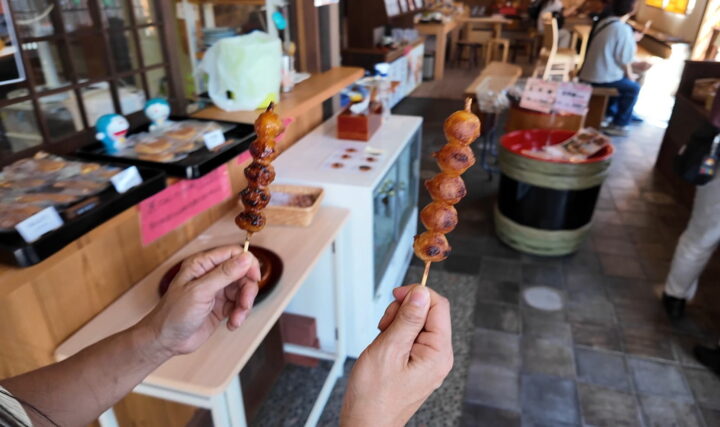 あけぼのやの店内で手にしたエゴマたれの団子と醤油みたらし団子