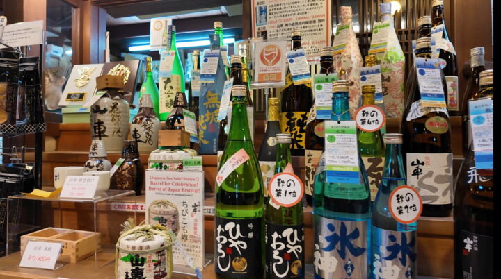 店頭に飾られたミニ菰樽や山車の様々な銘柄ボトル