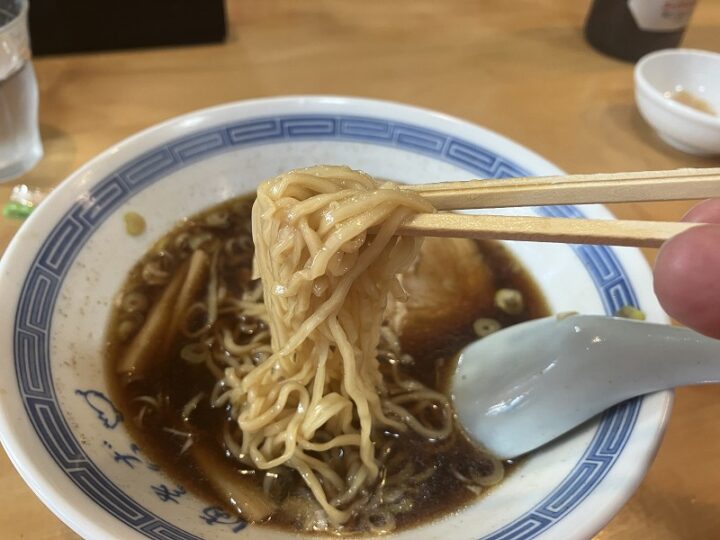 スープをしっかり纏った細縮れ麺