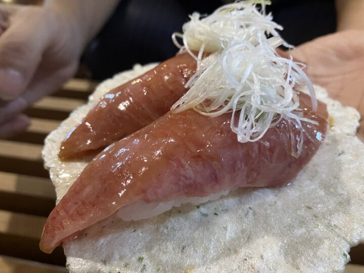 あおさ海苔せんべいの上に乗せられた白髪ねぎが添えられた飛騨牛トロさし握り