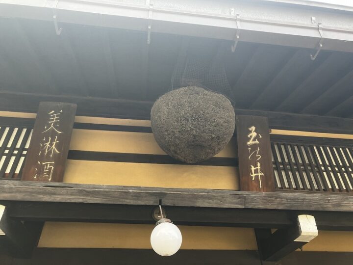 軒下に掲げられた美禄酒と玉の井の歴史ある木製看板と杉玉