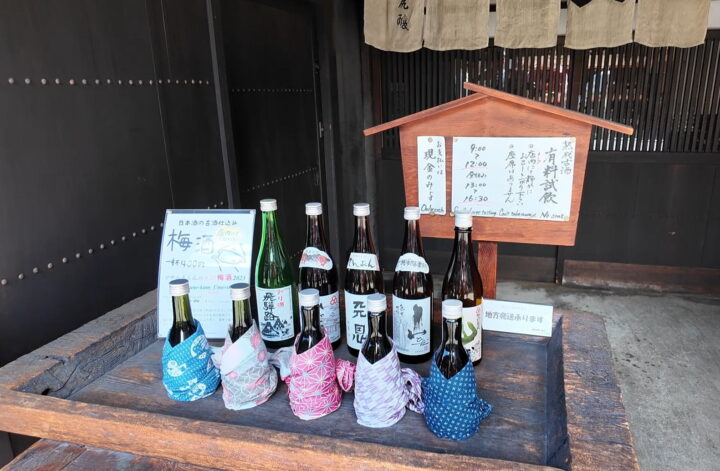 川尻酒造場の店頭に並ぶ熟成古酒の瓶と有料試飲の案内立て看板