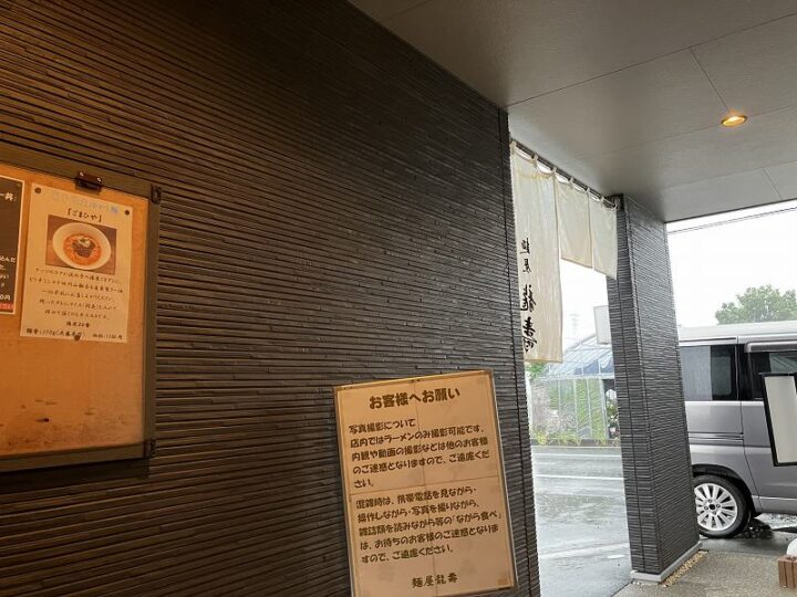 麺屋龍壽のシックな黒壁の店構えと白い暖簾
